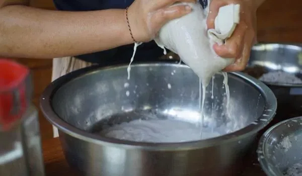 Squeezing coconut milk from grated coconut