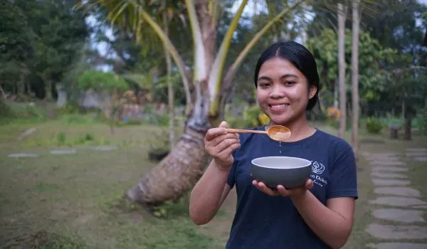 a girl pouring coconut oil on the farm