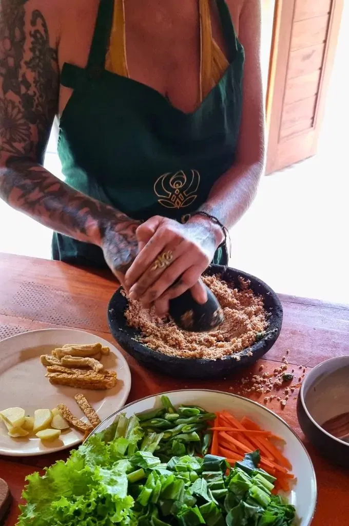 grinding peanut sauce using mortar and pestle