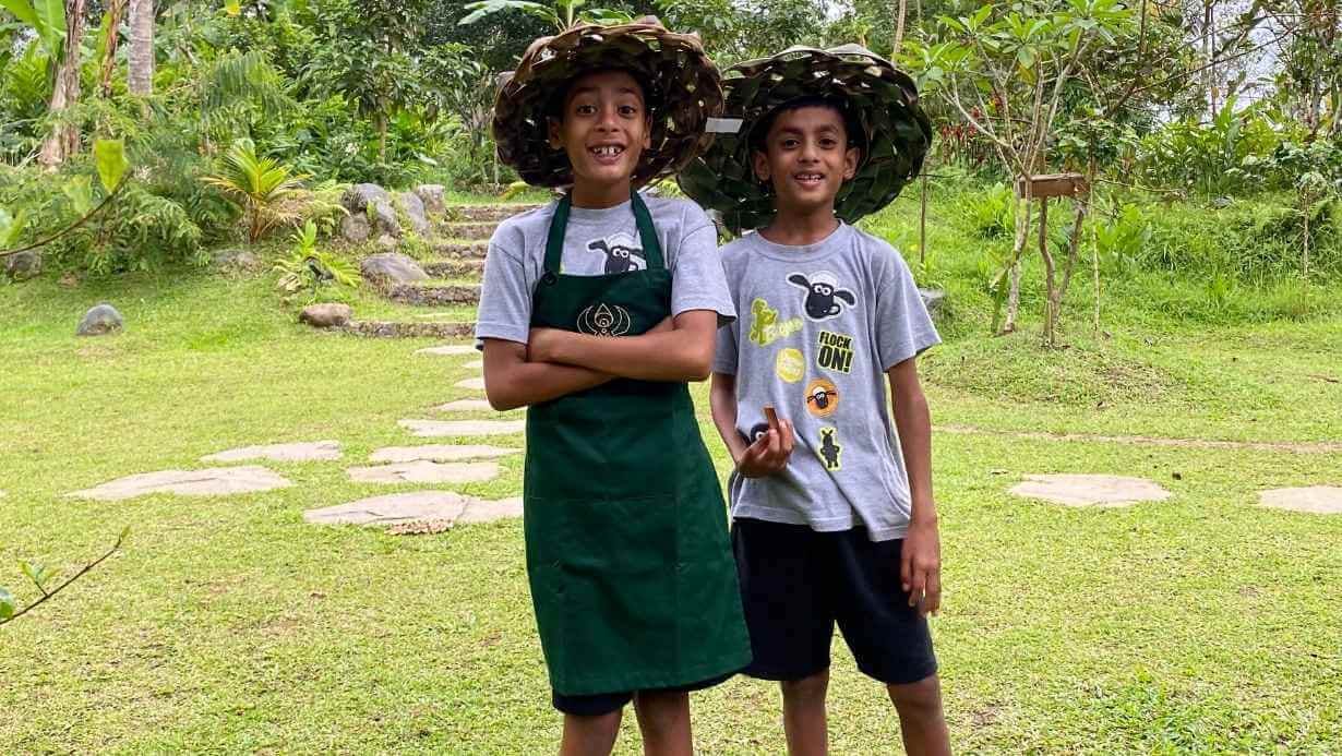 2 kids wearing traditional hat joining farm to table cooking class in Bali