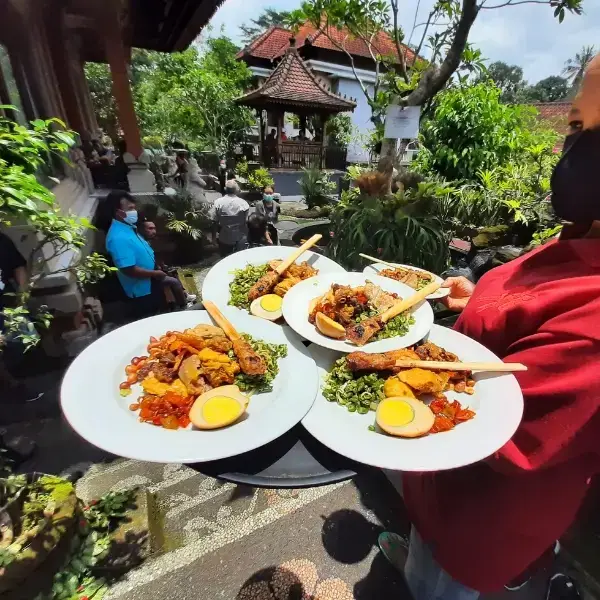 a women bring nasi campur in a local house in ubud to serve to the customers