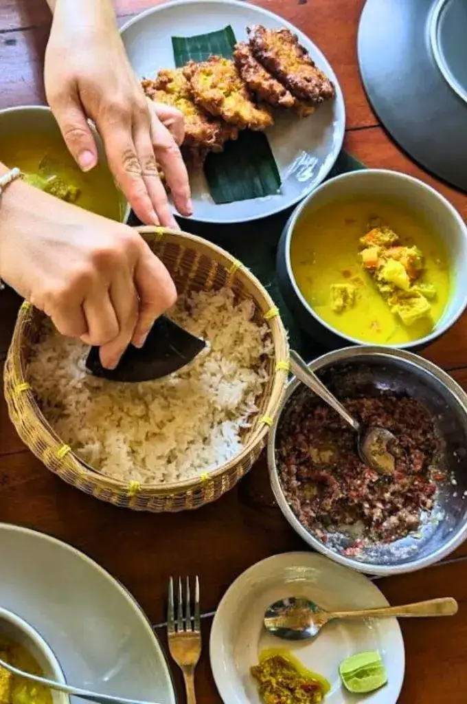 scooping the white rice and ready to eat after the cooking class in bali scooping the white rice and ready to eat after the cooking class in bali